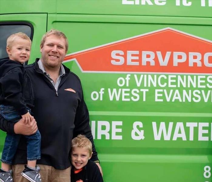owner Danny Drewes and son standing infront of SERVPRO green vehicle.